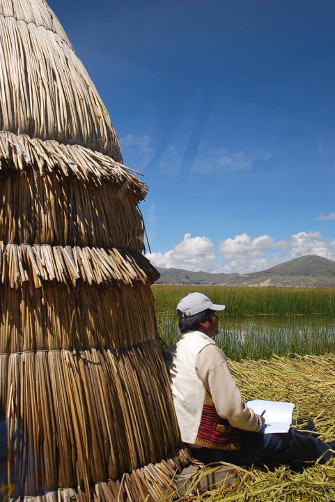 Man zit bij een hutje op de drijvende eilanden bij Puno